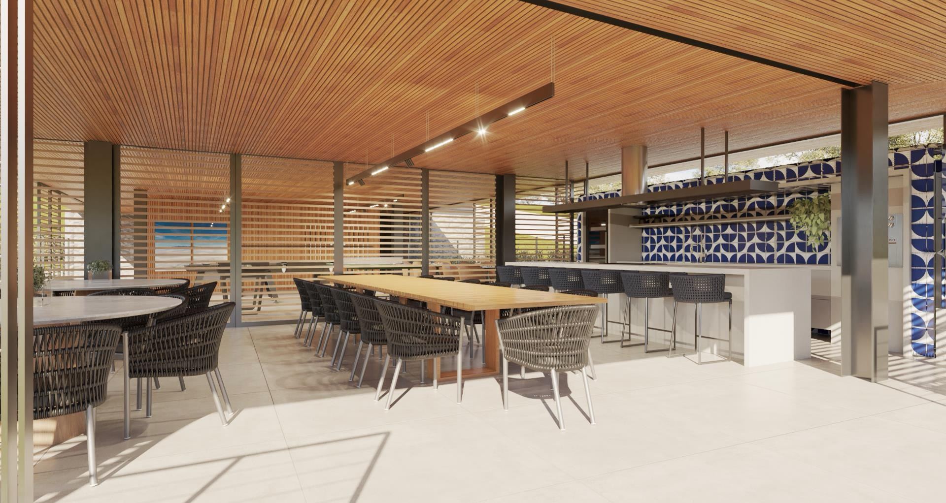 Área gourmet com mesa comprida de madeira e bancada de bar